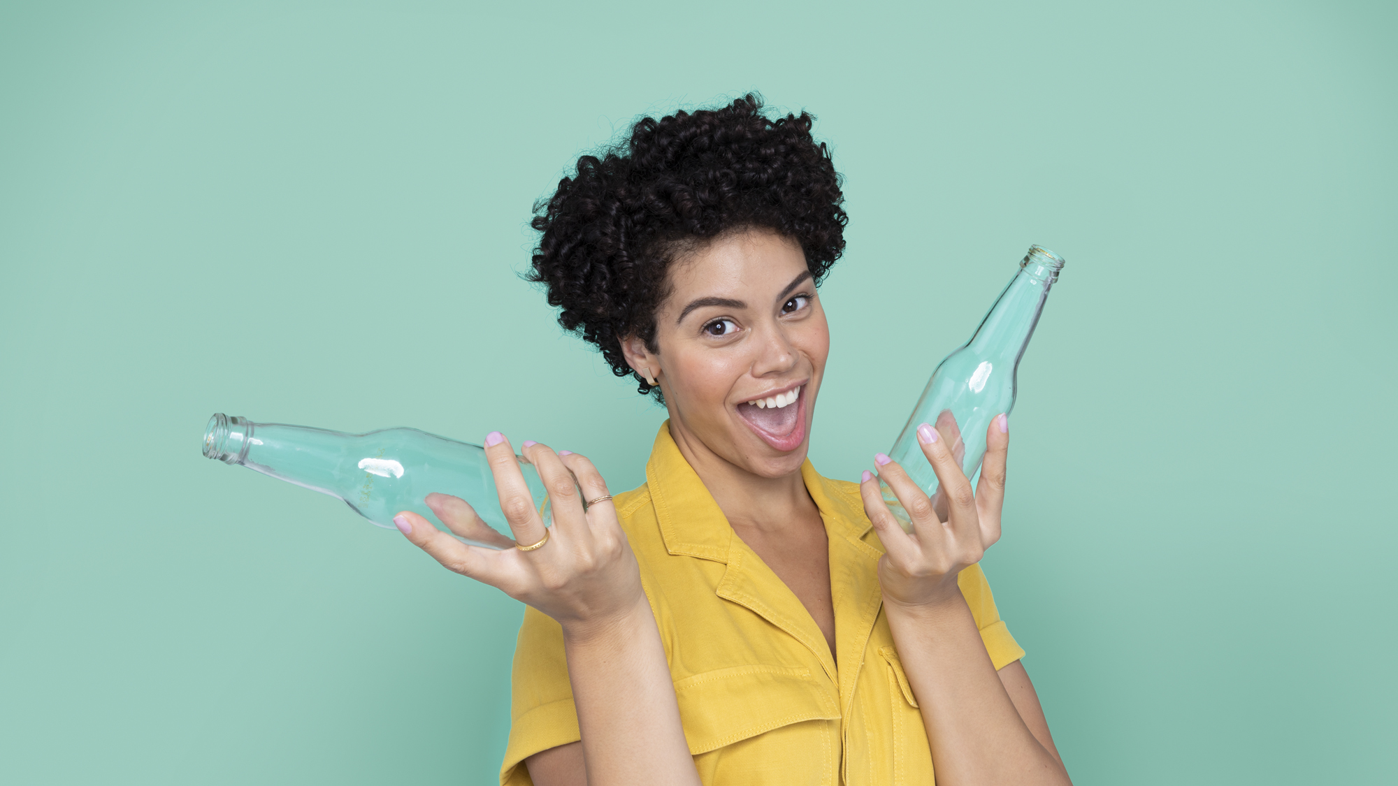 Smiling woman holding up two glass bottles 