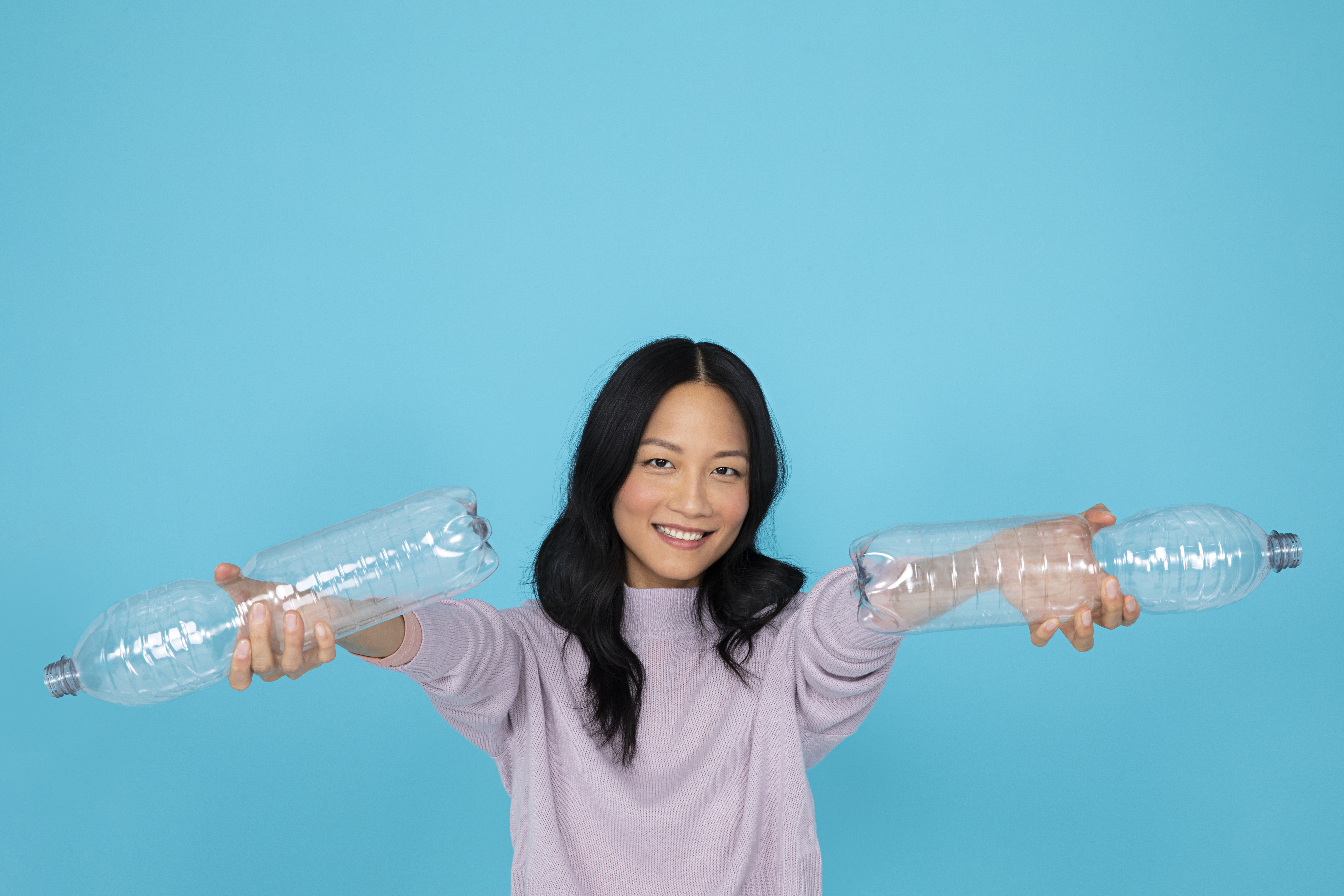 Asiatisches Mädchen hält PET-Flaschen