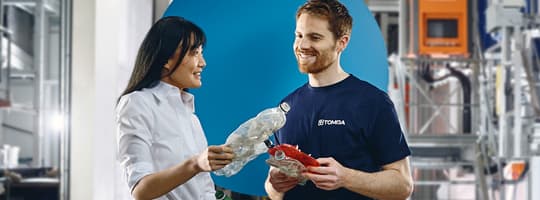 TOMRA employees with returned plastic bottle