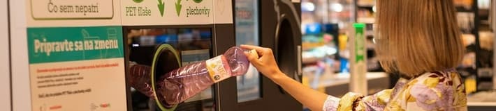 Woman feeding bottles in the reverse vending machine